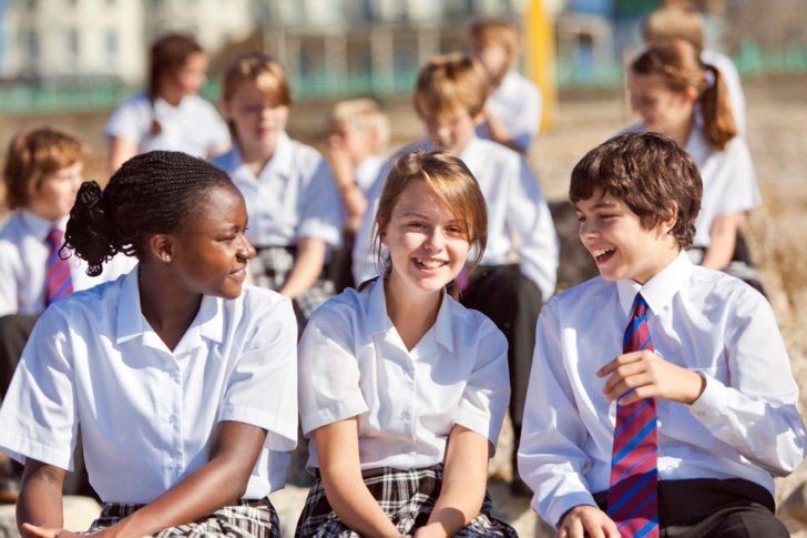  Lower School pupils sitting on the beach and enjoying talking to each other 