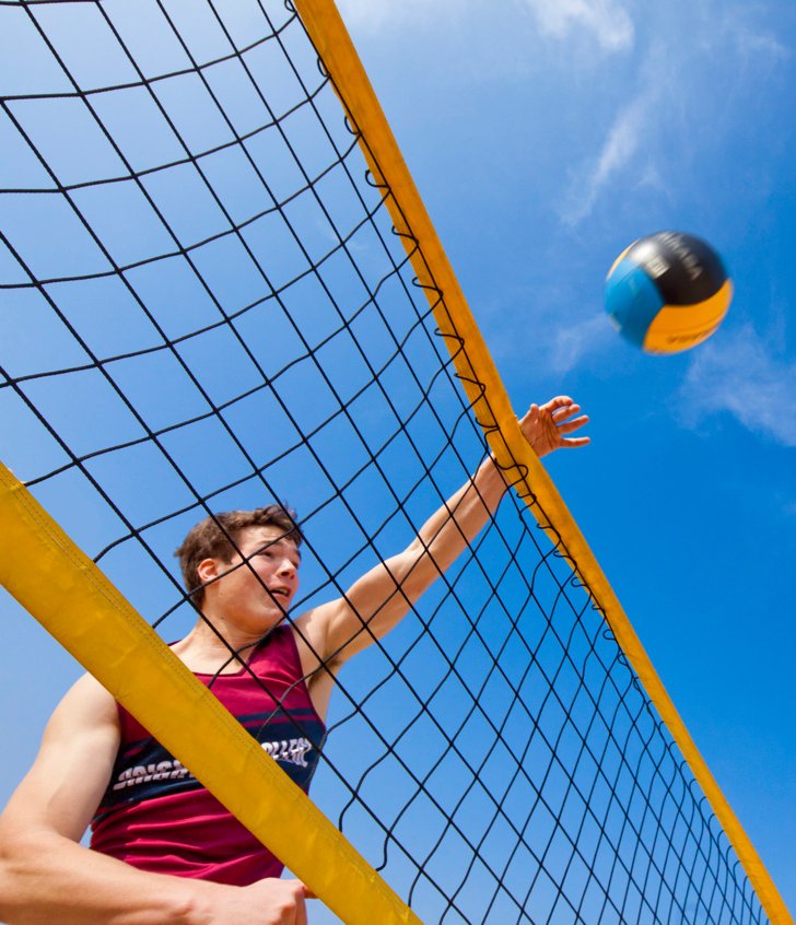  Pupil spiking the volleyball over the net on a sunny day at Yellowave 