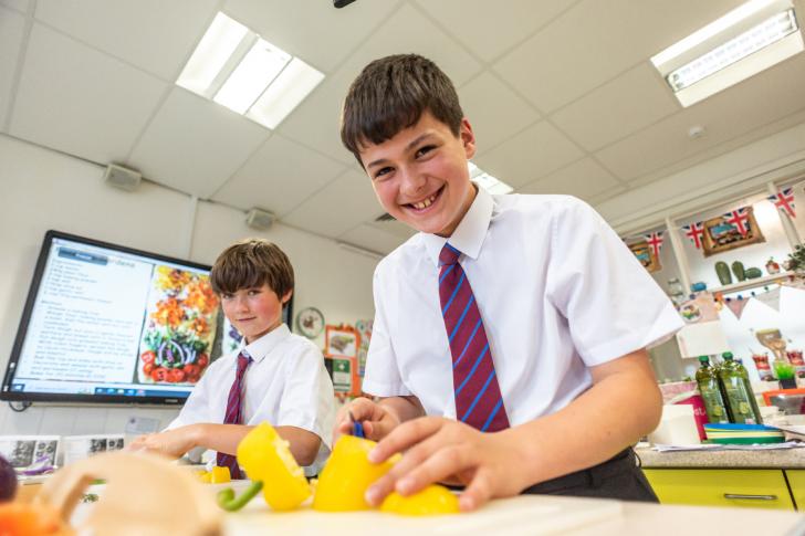  Prep School pupils in Cookery Club chopping up yellow peppers 