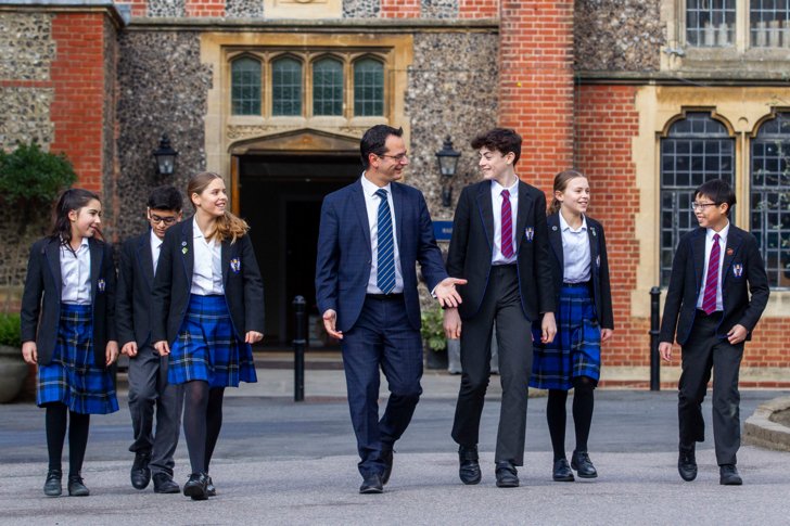  Prep-School pupils in uniform and Prep-School Headmaster Ant Falkus walking through the Quad 