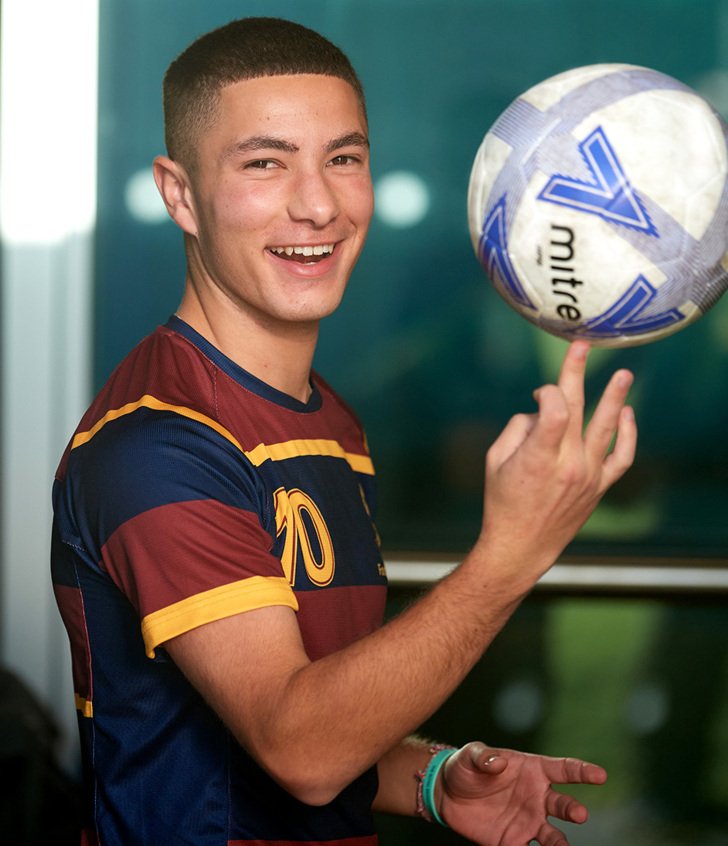  Pupil in 1st XI Football Team Kit spinning a football on his finger 