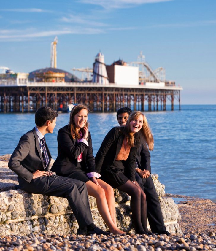  Sixth form pupils enjoying themselves on the beach in front of Brighton Pier 