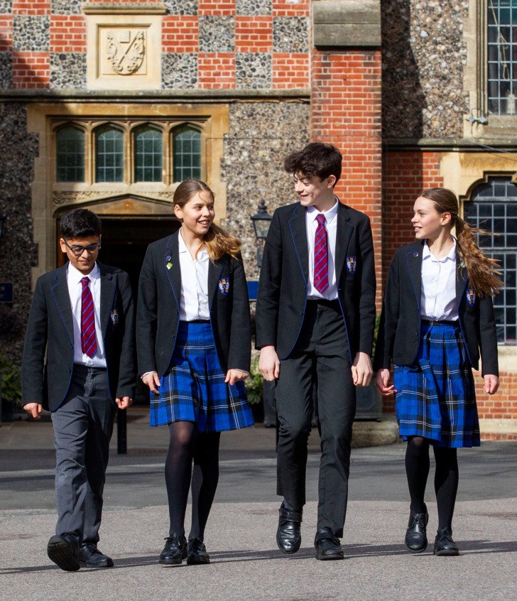  Prep-School pupils in uniform walking through the Quad and having a conversation 