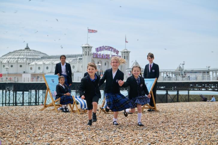  Pre-Prep pupils running along the stones on the beach in front of Brighton Pier 