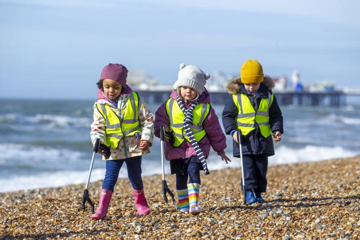  Pre-Prep pupils with litter pickers picking up rubbish on Brighton beach 