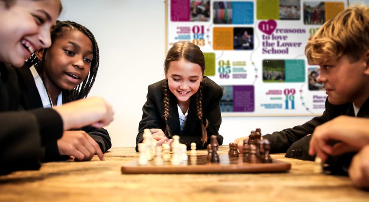  Lower School pupils sat at a table around a Chess board playing in their Common Room 