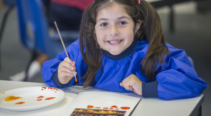  Prep School pupil in overalls painting in a lesson in the Art Room 