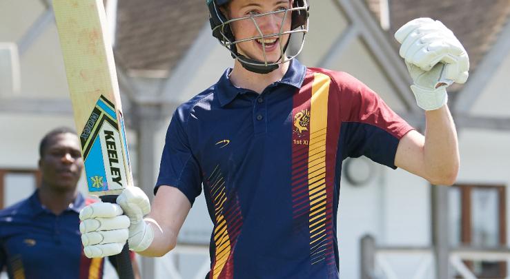  Pupil in 1st XI team cricket kit and batting kit enjoying playing in front of the Sammy Woods Pavilion in a Games session 