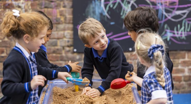  Pre-Prep pupils enjoying playing in the sandpit together in the playground 