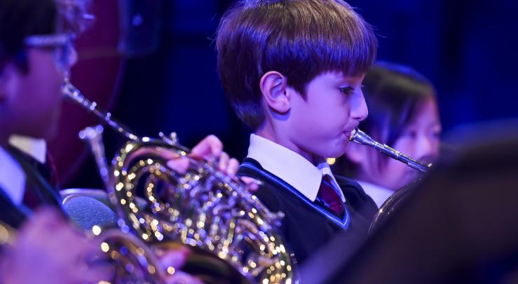  Prep School pupils playing brass instruments together in a concert in the Hall 