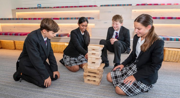  Pupils sitting on the floor in the Lower School Common Room playing Jenga 