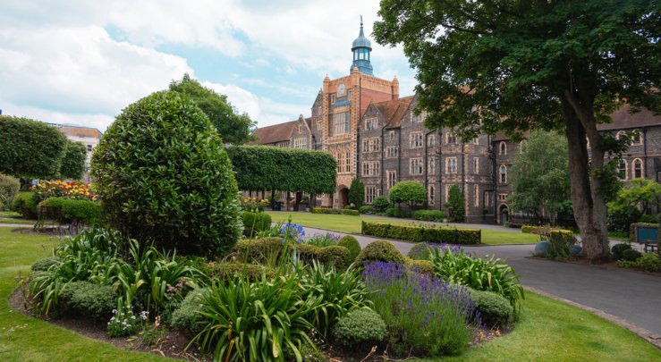  View across the Quad of the lawn and flowers with the Clock Tower in the background 