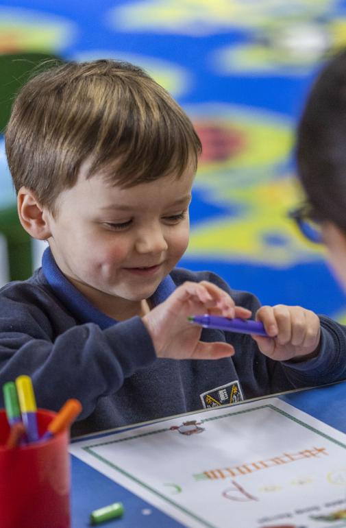  Nursery pupil enjoying drawing a picture in the classroom 