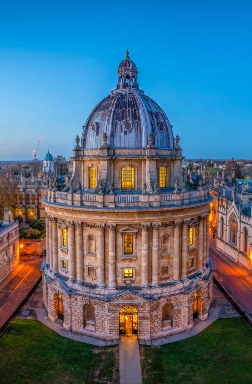  Radcliffe Camera at University of Oxford in the evening with glowing lights 